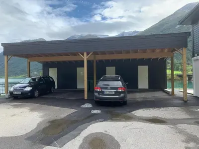 two cars parked in a garage with mountains in the background at Stryn Crystal Apartments - Waterfront Apartment in Stryn
