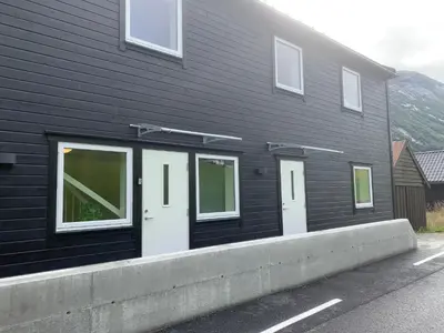 a black building with white doors on the side of it at Stryn Crystal Apartments - Waterfront Apartment in Stryn