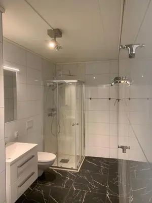 a bathroom with a shower and a toilet and a sink at Stryn Crystal Apartments - Waterfront Apartment in Stryn