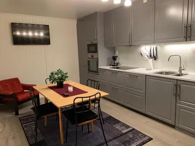 a kitchen with a table and chairs and a sink at Stryn Crystal Apartments - Waterfront Apartment in Stryn