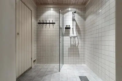 a bathroom with a shower with white tiles at Storelia in Hemsedal