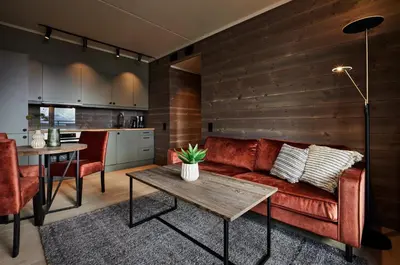 a living room with a red couch and a table at Ridderleiligheter in Beitostøl