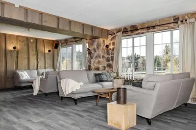 a living room with two couches and windows at Fossheim Lodge - arealeffektiv minileilighet in Torset