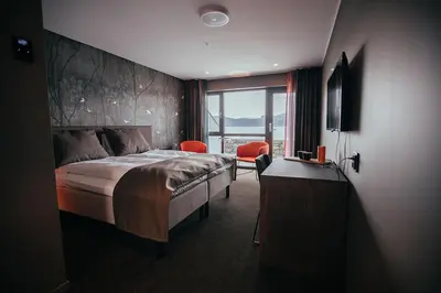 a bedroom with a bed and a desk and a window at Hardanger House in Jondal