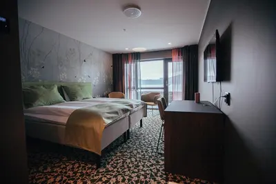 a bedroom with a bed and a desk and a window at Hardanger House in Jondal