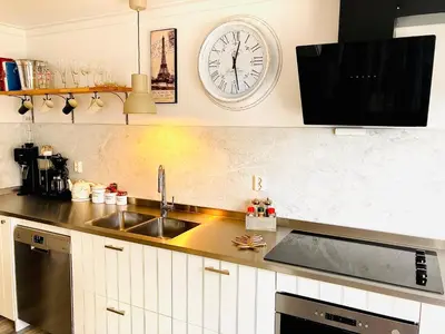 a kitchen with a sink and a clock on the wall at Apartments At The Sentrum in Kristiansund