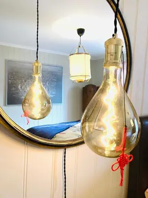 two light bulbs hanging in front of a mirror at Apartments At The Sentrum in Kristiansund