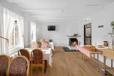 a living room with a table and chairs and a fireplace at Ulvik Camping in Ulvik