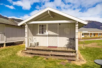 a small shed with a porch and a table and chairs at Ulvik Camping in Ulvik