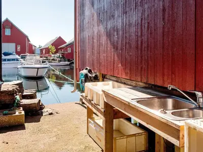 a kitchen with a sink and a boat in the water at 7 person holiday home in Bud in Bud