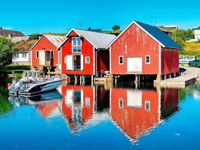 a group of houses on a body of water with a boat at 7 person holiday home in Bud in Bud