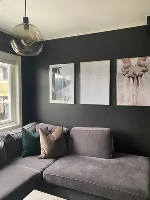 a couch in a living room with pictures on the wall at Oppdal Alpintun ski in ski out in Oppdal