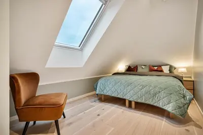 a bedroom with a bed and a chair at Keyser Apartments 8 in Bergen