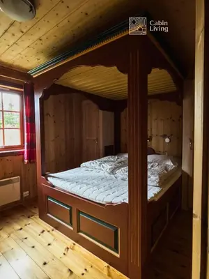 a large wooden bed in a wooden room at Large Cottage 2 Baths and Sauna in Sjusjøen in Lillehammer