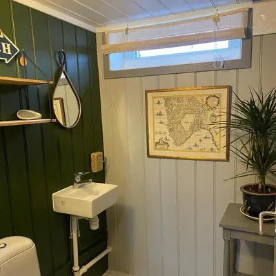 a bathroom with a sink and a map on the wall at Bjørkli Lodge in Geilo