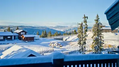 a snow covered yard with trees and a house at Large family cabin in Hafjell ski in-out, BBQ, terrace and fireplace in Hafjell