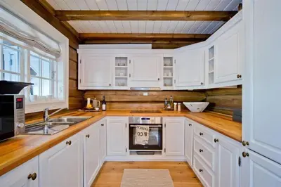 a kitchen with white cabinets and a sink at Large family cabin in Hafjell ski in-out, BBQ, terrace and fireplace in Hafjell