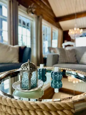 a living room with a glass table with a lantern on it at Large family cabin in Hafjell ski in-out, BBQ, terrace and fireplace in Hafjell