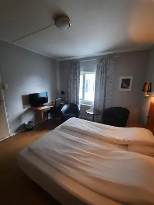 a hotel room with a large bed and a desk at Sunndalsøra Hotell in Sunndalsøra