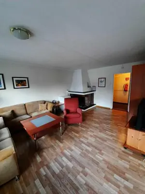 a living room with a couch and a red chair at Sunndalsøra Hotell in Sunndalsøra