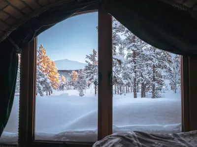 a view of a snow covered forest from a window at Eventyrhyttene i Jotunheimen in Stuttgongfossen