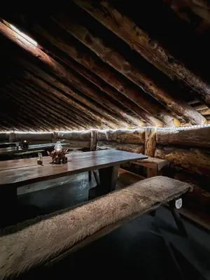 a wooden table in an attic with a bench at Eventyrhyttene i Jotunheimen in Stuttgongfossen