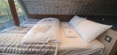 a bed with white sheets and a book on it at Eventyrhyttene i Jotunheimen in Stuttgongfossen