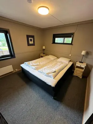 a bedroom with a bed in a room with two windows at Lom Apartment in Lom