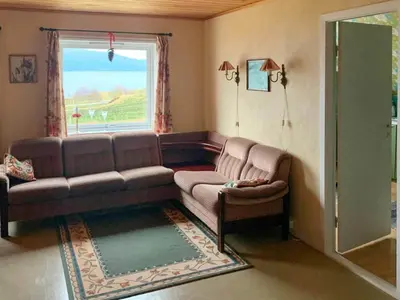 a living room with a couch and a window at 10 person holiday home in Brekke in Brekke