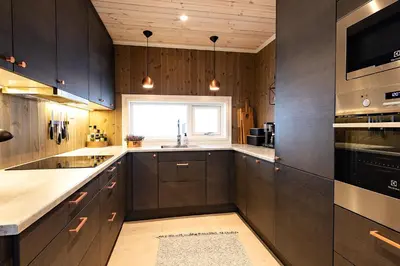 a kitchen with wooden cabinets and a window at Lykkeli in Stranda
