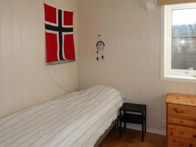 a bedroom with a bed with a flag on the wall at Holiday Home Jektastøo by Interhome in Nordhuglo