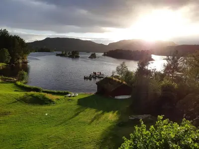 a group of people on a boat in a lake at Teigen Leirstad, feriehus og hytter in Eikefjord