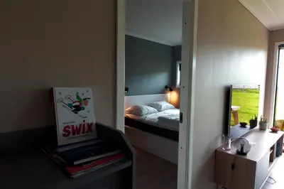 a small bedroom with a bed and a mirror at Lys og moderne leilighet rett ved skiløypa på Nordseter - Kort vei til Sjusjøen, Lillehammer og Hafjell - Dyr ikke tillatt in Nordseter