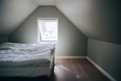 an attic room with a bed and a window at Odda Apartments - 2BR & 3BR - Parking - T32 in Odda