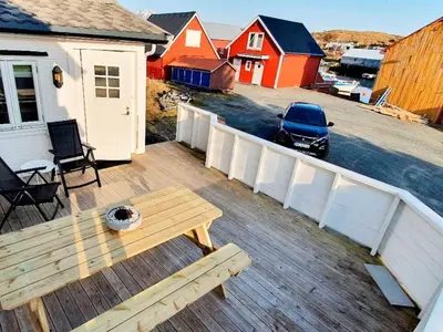 a wooden deck with a wooden table and a bench at 6 person holiday home in Bud in Bud