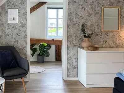 a living room with a chair and a mirror at 6 person holiday home in Bud in Bud