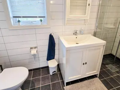 a bathroom with a white sink and a toilet at 6 person holiday home in Bud in Bud