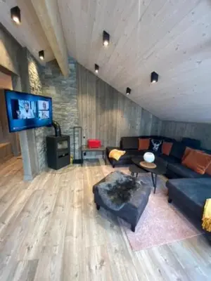 a living room with a couch and a tv at Villa Solsiden Geilo in Geilo