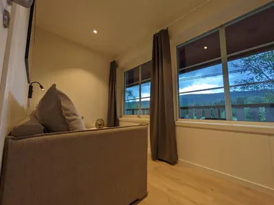 a living room with a couch and two windows at Villa Fregn in Ljørdal