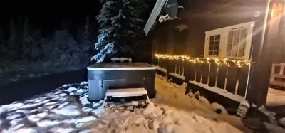 a house with a bench in the snow at night at Villa Fregn in Ljørdal