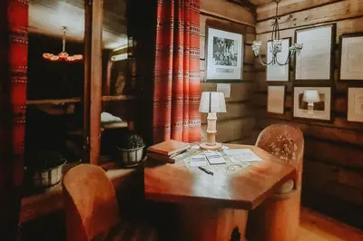 a wooden table with two chairs and a lamp on it at Villa Fregn in Ljørdal