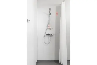 a bathroom with a shower in a white room at Aiden by Best Western Trondheim Airport in Stjoerdal