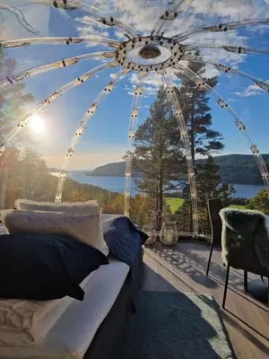 a bedroom with a view of a ferris wheel at Glassigloo med panoramautsikt - Nordlys og stjernehimmel - Fosen in Husby
