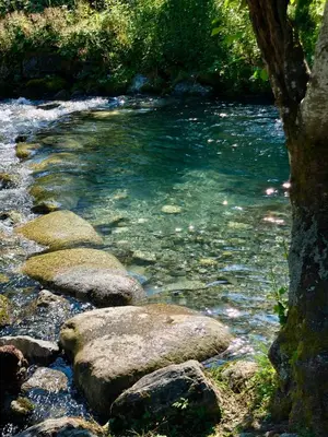 a river with some rocks in the water at Melkevoll Bretun Camping in Briksdalsbre