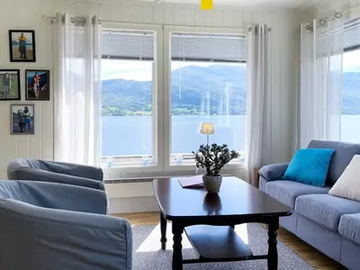 a living room with a table and a large window at 5 person holiday home in averøy in Stokke