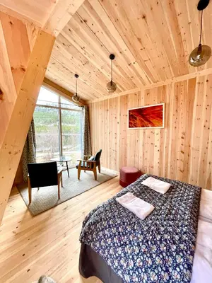 a bedroom with a bed in a room with wooden walls at Reinheimen Lodge in Skjåk