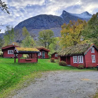 a group of houses with a mountain in the background at Lensmansgarden in Innfjorden