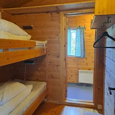 a bedroom with two bunk beds and a window at Lensmansgarden in Innfjorden