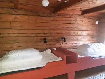 a bed in a room with a wooden wall at Lensmansgarden Marteinsgarden in Innfjorden