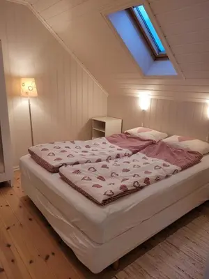 a bedroom with a large bed with a skylight at Flohytta in Stryn